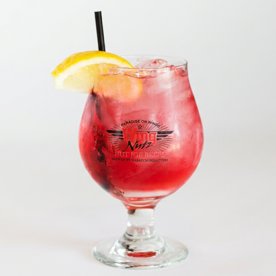 Red fruit cocktail with ice, lemon garnish, and straw served in a branded goblet.